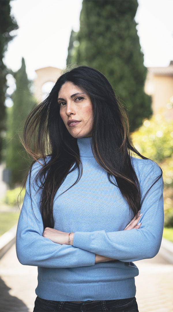 Donna indossa maglia ciclista in lana e cashmere blu, ideale per la stagione fredda. Stile chic e comfort per look esclusivi e versatili.